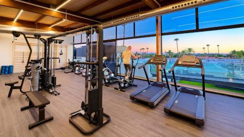 a gym with several treadmills and a man in the background at Club Maspalomas Suites & Spa - Adults Only in Maspalomas