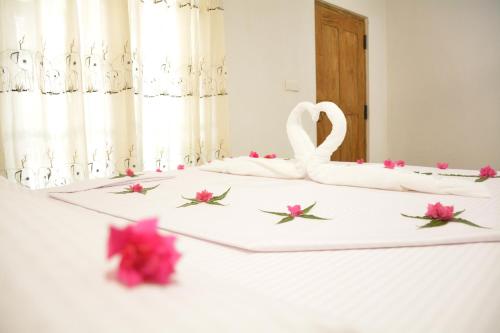 a bed with a swan and flowers on it at Jaye Eco Lodge in Habarana