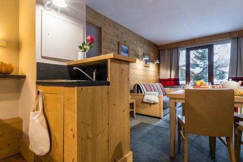 uma cozinha e sala de jantar com um lavatório e uma mesa em Résidence Pierre & Vacances Les Balcons De Bellevarde em Val dʼIsère