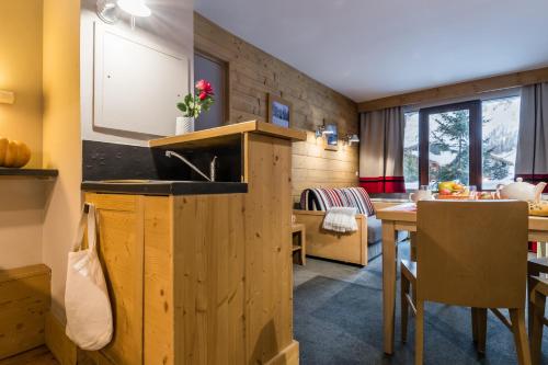 - une cuisine et une salle à manger avec un évier et une table dans l'établissement Résidence Pierre & Vacances Les Balcons De Bellevarde, à Val dʼIsère