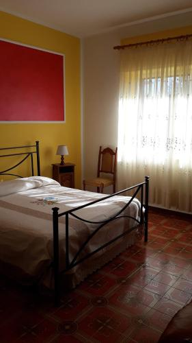 a bedroom with a bed and a window with curtains at Casa Mirella in Bolsena