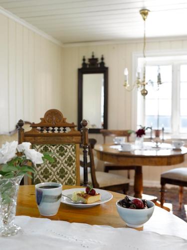 a dining room with a table with a plate of food at Husfrua Gårdshotell in Straumen