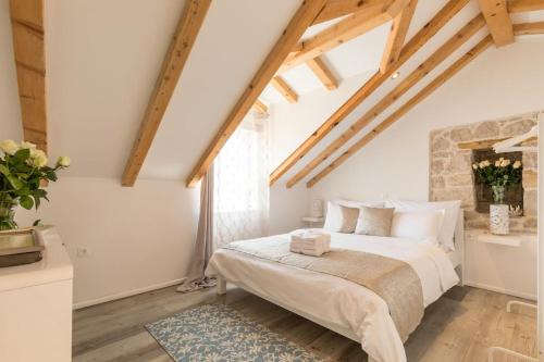 Un dormitorio con una cama grande en una habitación con techos de madera. en Guest House Kala, en Split