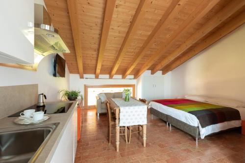 een keuken en een woonkamer met een tafel en een bed bij Agriturismo Casa Fiorindo in Meolo