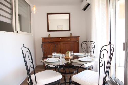 a dining room with a table and chairs and a mirror at Le Renoir in Nice