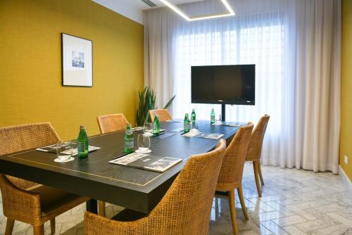 a dining room with a table with chairs and a television at Melody Hotel - an Atlas Boutique Hotel in Tel Aviv