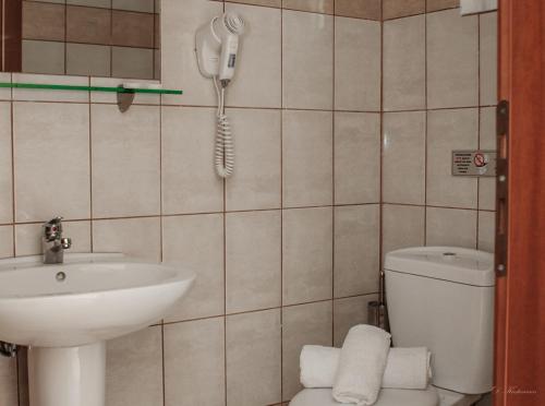 a bathroom with a sink and a phone on the wall at Musses in Kókkinon Nerón