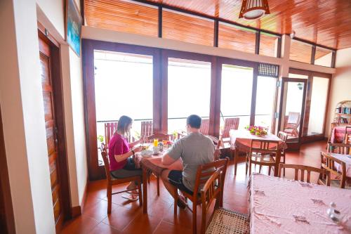 Un uomo e una donna seduti a un tavolo in un ristorante di Mcleod-Inn a Kandy