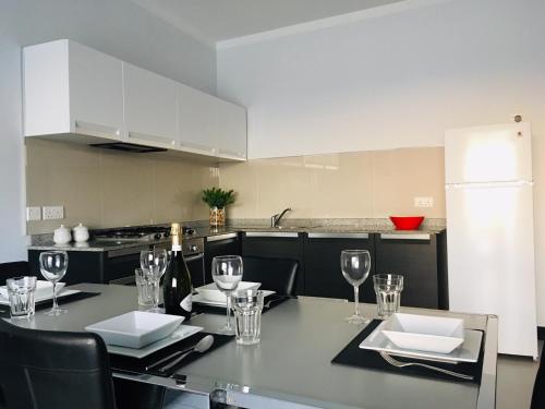 a kitchen with a table with wine glasses on it at Moby Dick Xlendi Holiday Apartments in Xlendi