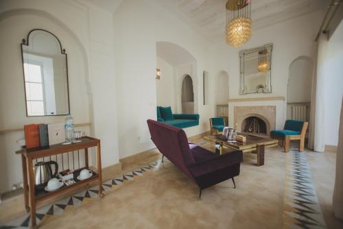 a living room with a couch and a table and a fireplace at Les Deux Tours in Marrakech