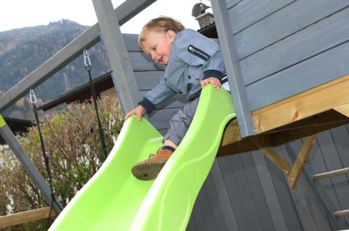 a young child on a slide on a playground at Chalet Georg in Kaprun