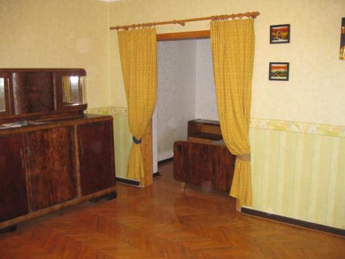 Private apartment in Tallin Kalamaja في تالين: غرفة معيشة مع ستائر صفراء وارضية خشبية