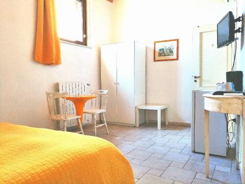 een slaapkamer met een bed, een tafel en een bureau bij Corte Del Borgo Antico in Bari