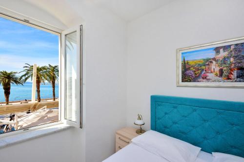 a bedroom with a window with a view of the ocean at Hotel Adriana in Split