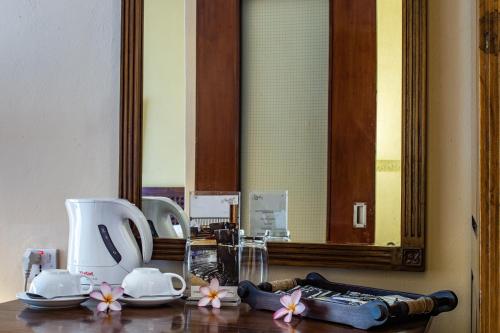 a bathroom counter with a mirror and a sink at Aanari Hotel & Spa- Mauritius in Flic-en-Flac