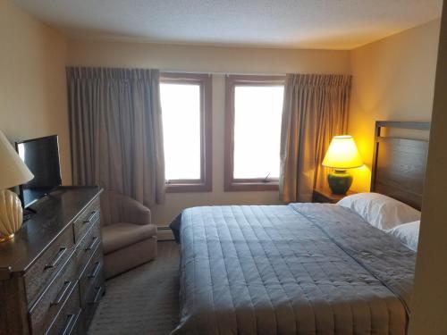 a hotel room with a bed and a television at Ski In/Out Trailside Townhome in Killington