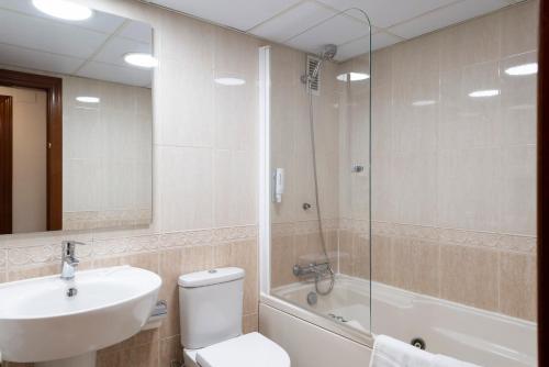 a bathroom with a sink, toilet and bathtub at Aparthotel Los Girasoles in Zaragoza
