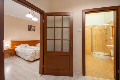 ロンデク・ズドルイにあるZdrój Wojciechのベッドルーム1室(ベッドにつながるドア付)
