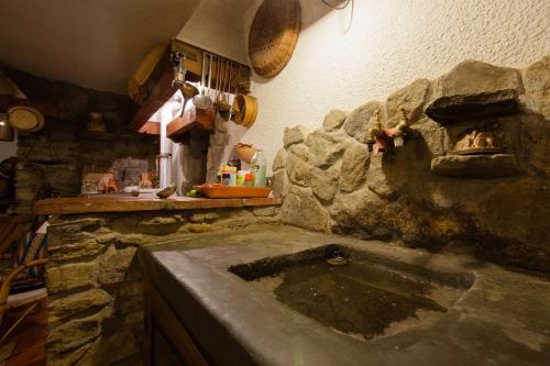 cocina con fregadero de piedra en una habitación en Casolare Il Condottiero Holiday House, en Castiglion Fiorentino