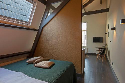 een slaapkamer met een bed met 2 kussens en een raam bij Loft Studio's in Zandvoort