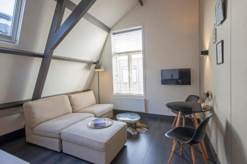 ein Wohnzimmer mit einem Sofa und einem Tisch in der Unterkunft Loft Studio's in Zandvoort