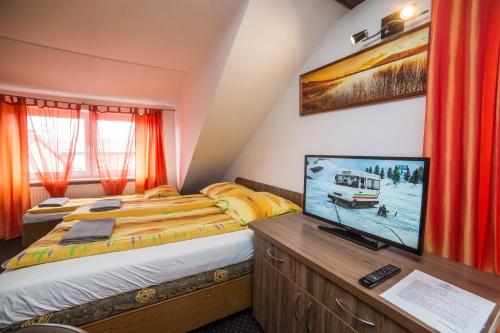 una camera da letto con un letto e una TV a schermo piatto di Dom Wczasowy Barbara a Karwia