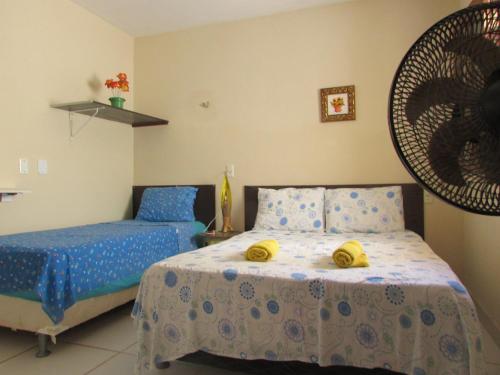 Un dormitorio con una cama con toallas amarillas. en Apartamentos Casa Veneza, en Canoa Quebrada
