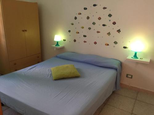 ein Schlafzimmer mit einem Bett mit zwei Lampen an der Wand in der Unterkunft San Vito Lo Capo Via Savoia 250 Casa vacanze in San Vito lo Capo