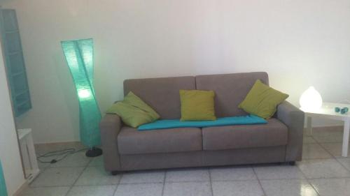 a couch with two yellow pillows in a living room at San Vito Lo Capo Via Savoia 250 Casa vacanze in San Vito lo Capo