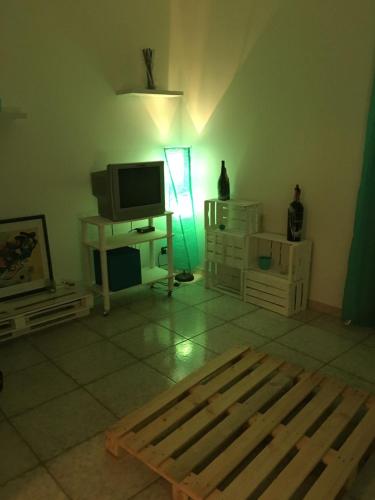 ein Wohnzimmer mit einem TV und einem Tisch in der Unterkunft San Vito Lo Capo Via Savoia 250 Casa vacanze in San Vito lo Capo
