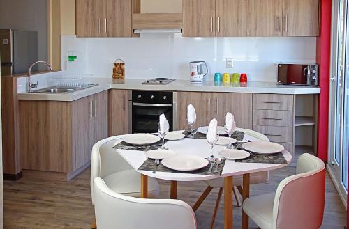a kitchen with a table and chairs in a kitchen at Departamentos Nómades del Lago in Puerto Varas