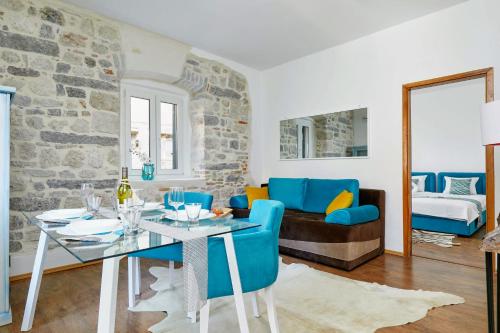 een woonkamer met een tafel en blauwe stoelen bij La Rocca Apartment Old Town Kotor in Kotor