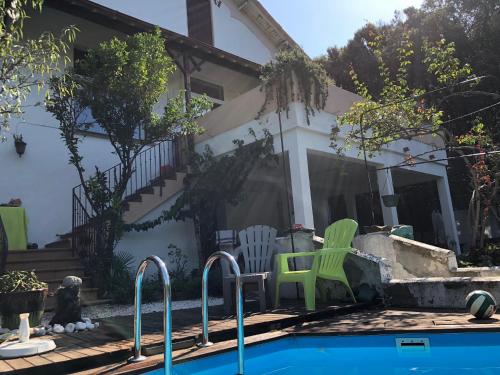 ein Haus mit einem Pool mit zwei grünen Stühlen in der Unterkunft La Sala in Amélie-les-Bains-Palalda