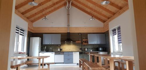a large kitchen with wooden ceilings and wooden tables at Dom Goscinny Skarpa in Krynica Zdrój