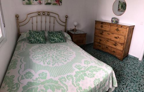 een slaapkamer met een groot bed en een houten dressoir bij El Balcón de Rosita in Morche