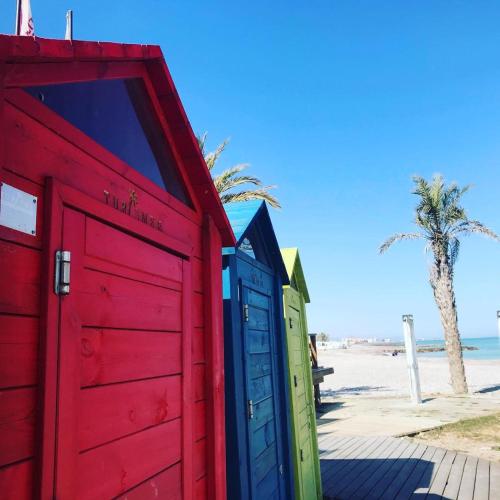 a row of colorful beach huts on the beach at BEACH & SUN MONCOFA in Moncófar