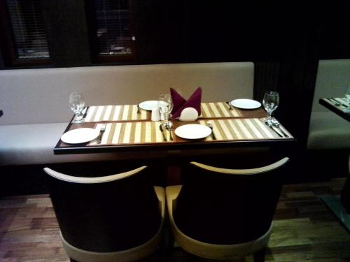 a table in a restaurant with a table set with plates and glasses at Mark Inn Hotel Deira in Dubai