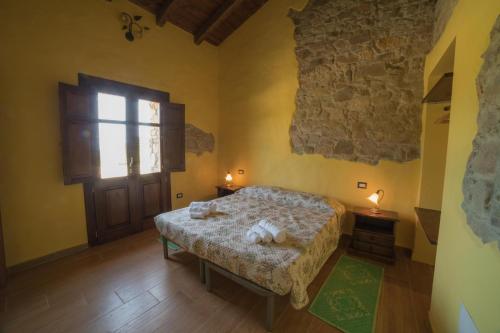 a bedroom with a bed and a window and a door at Arroccas de is Istellas in Arbus