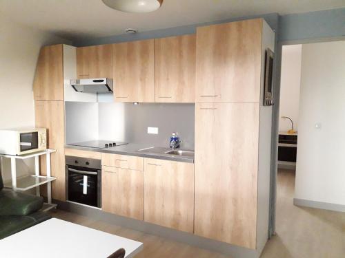 a kitchen with wooden cabinets and a sink at Tiguil in Le Guilvinec