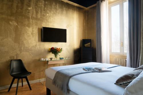 - une chambre avec un lit et une télévision murale dans l'établissement Rivière Private Rooms at the Park, à Milan