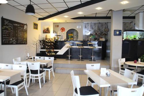 un restaurante con mesas blancas y sillas blancas en M&M Spanie, en Leszno
