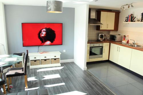 a kitchen with a tv hanging on the wall at Empire Serviced Apartments in Hinckley