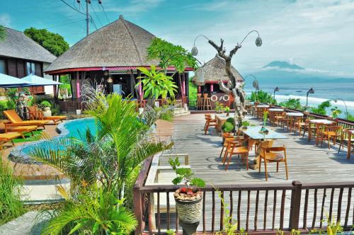 a resort with a pool and tables and chairs at Ocean Terrace Suite And Spa Luxury in Nusa Penida