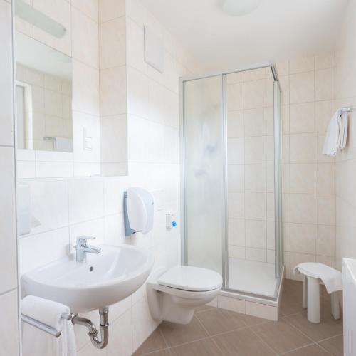 a bathroom with a toilet and a sink and a shower at Hotel Kindler 2,0 Self-Check-In in Leoben