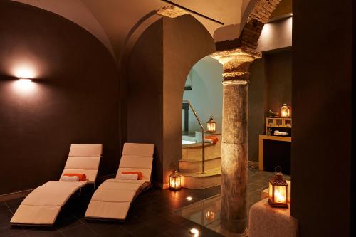 a room with white chairs and a column with a mirror at The Code Hotel in Rome