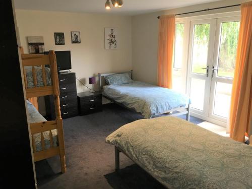 1 dormitorio con 2 literas y ventana en Country House Ashdene, en Highworth