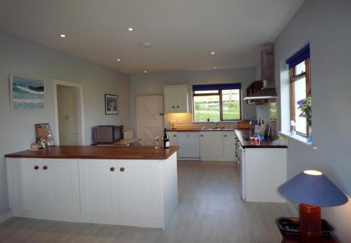 a kitchen with white cabinets and a counter top at Dingle Bay View in Dingle