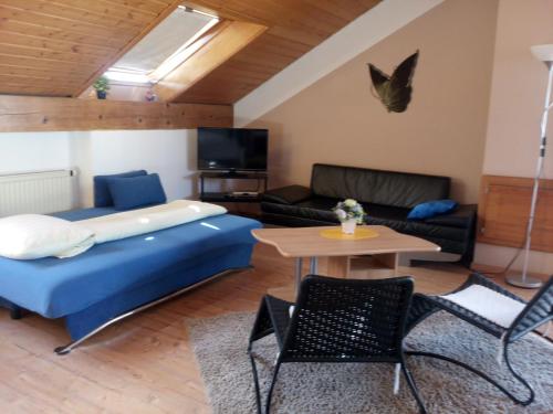 sala de estar con cama azul y sofá en Gaestehaus Kasper en Kenzingen