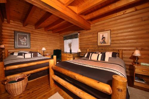 a bedroom with two beds in a log cabin at Tuckamore Lodge in Main Brook