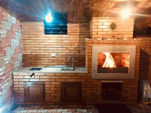 a kitchen with a fireplace in a brick wall at Cottage Euro Style in Ureki